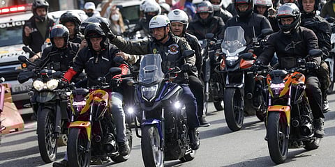 Brazilian President Jair Bolsonaro waves as he leads a caravan of motorcycle enthusiasts following him through the streets of Sao Paulo. (Photo| AP)