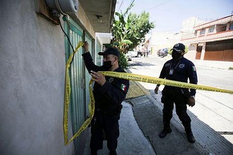 A police officer marks a security perimeter around the house where bones were found under the floor in the Atizapan municipality of the State of Mexico, Thursday, May 20, 2021. (Photo | AP)