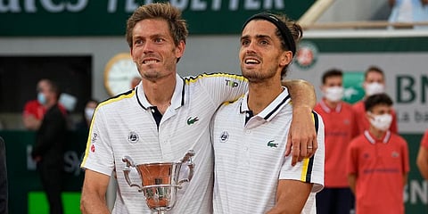 Nicolas Mahut (L) and Pierre-Hugues Herbert hold tier trophy after defeating Alexander Bublik and Andrey Golubev in their men's doubles final match of the French Open tournament. (Photo | AP)