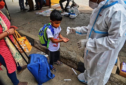Health workers give sanitiser to a boy after collecting his swab sample in Bengaluru. (Photo | Shriram BN, EPS)