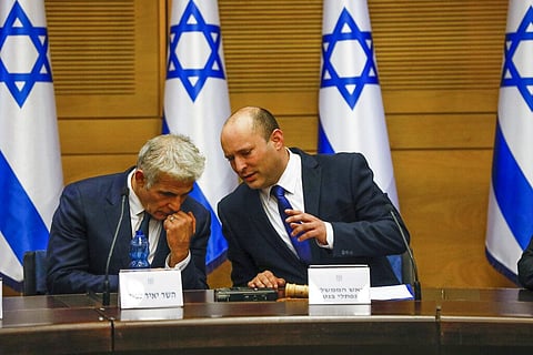 Israel's new prime minister Naftali Bennett talks to Yair Lapid during a first cabinet meeting in Jerusalem Sunday. (Photo | AP)