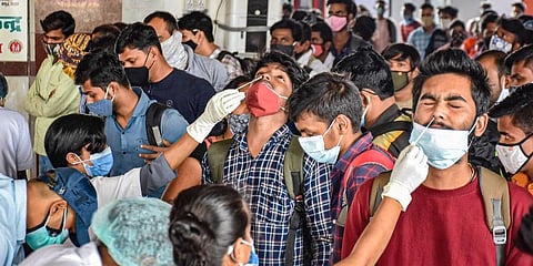 Health workers collect swab samples of the passengers arriving from Maharashtra at a COVID-19 testing counter at Patna railway station. (Photo | PTI)