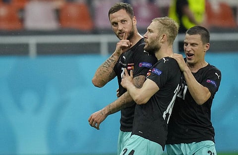 Austria's Marko Arnautovic, left, celebrates with teammates after scoring his side's third goal during the Euro 2020. (Photo | AP)