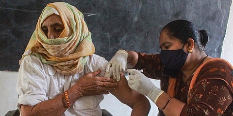 A health worker administers a dose of COVID-19 vaccine to a woman in Gurugram. (Photo | PTI)