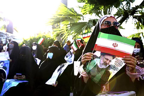 A supporter of presidential candidate Ebrahim Raisi holds a sign and the Iranian flag during a rally in Tehran, Iran, Wednesday, June 16, 2021. (Photo | AP)
