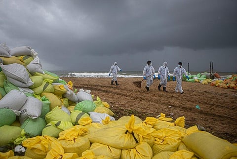 Sri Lankan navy soldiers walk on the beach looking for plastic debris washed ashore from fire damaged container ship MV X-Press Pearl on Colombo outskirts. (Photo | AP)