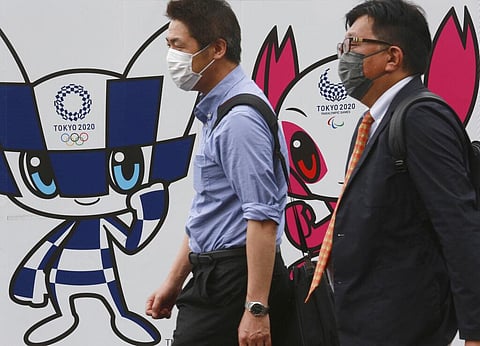 People walk by posters to promote the Olympic Games planned to start in the summer of 2021, in Tokyo. (Photo | AP)