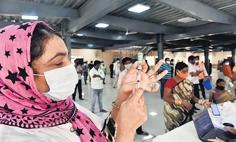 People wait in line to get vaccinated at a multi-purpose function hall at Champapet in Hyderabad on Friday. (Photo | Vinay Madapu, EPS)