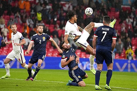 England's Tyrone Mings, second right, attempts a, overhead shot at goal while grabbing the shirt of Scotland's Grant Hanley during the Euro 2020 soccer championship. (Photo | AP)