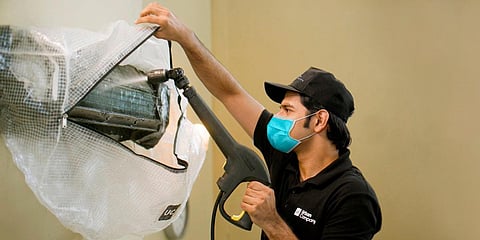 Representational image of a repairman from Urban Company fixing an AC