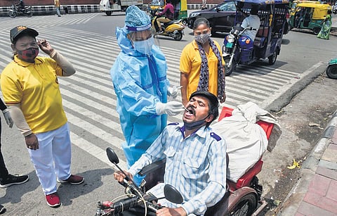 A medic collects a swab sample from a man for Covid-19 testing. (File photo| PTI)