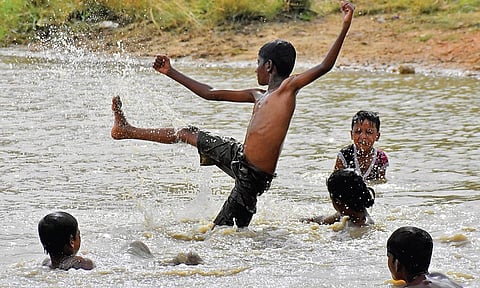 Children enjoy in a lake near Tirupati on Saturday. (Photo | Madhav K, EPS)