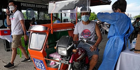 A pedicab driver is inoculated with China's Sinovac COVID-19 Vaccine in Manila. (Photo | AP)