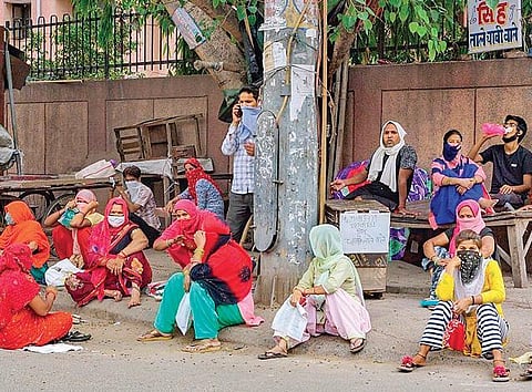 File photo shows women waiting to collect free ration in East Delhi. (Photo | PTI)