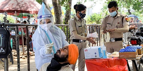 A medic collects a swab sample from a man for Covid-19 testing, in New Delhi. (Photo | PTI)