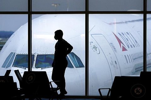 A passenger wears a face mask to help prevent the spread of the new coronavirus as he waits for a Delta Airlines flight. (Photo | AP)
