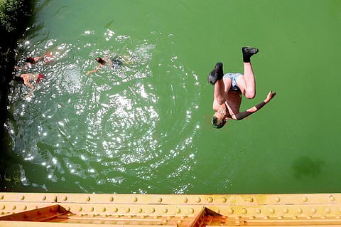 In this file photograph taken on June 25, 2019, youth jump into a canal near Reims, north-eastern France, as temperatures soar. (Photo | AFP)