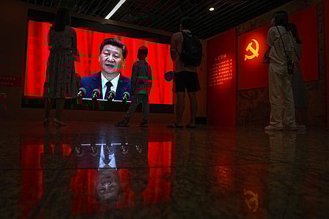 Visitors watch a screen showing Xi Jinping speaking next to a Communist Party's flag, at an exhibition promoting China's achievement under communist party from 1921 to 2021. (Photo | AP)
