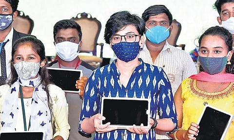 Students pose with the tablet PCs distributed by the State Government in Bengaluru on Wednesday | nagaraja gadekal
