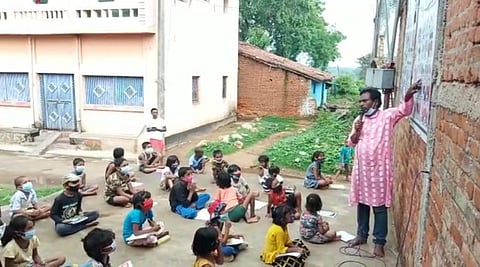 Teacher Bhim Mahto teaching students at the temple, Jinouri village in Bokaro district of Jharkhand.