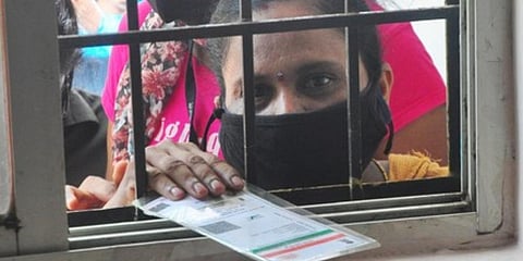 A woman with her Aadhaar card. (Photo | EPS)