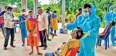 Health workers collect samples for Covid-19 test at Tummalapalli Kalakshetram in Vijayawada on Saturday. (Photo | EPS/Prasant Madugula)