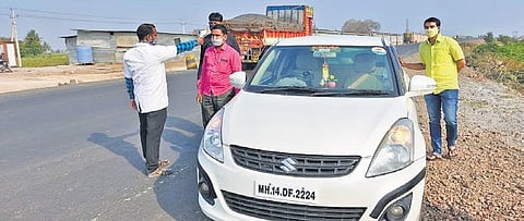 Officials stop a motorist at the inter-state border with Maharashtra in Vijayapura. (Photo| EPS)