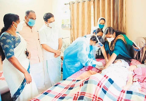 A bed-ridden patient being vaccinated by the health workers from Valanthakad PHC as part of the initiative launched by the Maradu municipality. (Photo| EPS)