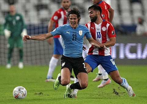 Uruguay's Edinson Cavani, left, is fouled by Paraguay's Alberto Espinola during a Copa America soccer match at Nilton Santos stadium. (Photo | AP)