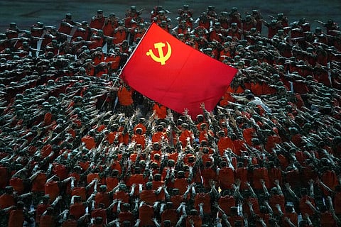 Performers dressed as rescue workers gather around the Communist Party flag during a gala show ahead of the 100th anniversary of the founding of the Chinese Communist Party in Beijing. (Photo | AP)