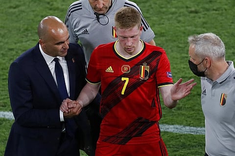 Belgium's Kevin De Bruyne leaves the match injured flanked by Belgium's manager Roberto Martinez. (Photo | AP)