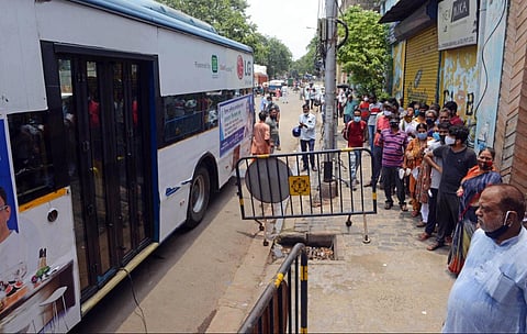 Beneficiaries stand in a queue near a bus to get vaccines against COVID-19 after the inauguration of 'Vaccination on Wheel' at Posta Bazar, in Kolkata on Thursday. (Photo | ANI)