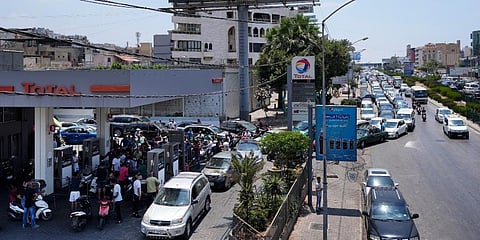 Drivers wait in a long line to get fuel at a gas station under a billboard showing Iranian Revolutionary Guard Gen. (Photo | AP)