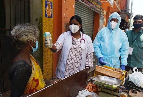 A health worker checking temperature of a vegetable vendor to keep a check on the spread of Covid-19 in Chennai. (Photo | R Satish Babu, EPS)