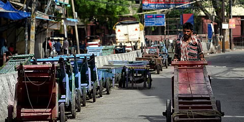 A worker pushes a handcart during the lockdown imposed amid the rise in COVID-19 cases in New Delhi. (Photo| ANI)