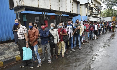 People wait in a queue for a bus after unlocking of COVID-19 lockdown began in a phased manner, at Bandra in Mumbai, Monday, June 7, 2021. (Photo | PTI)