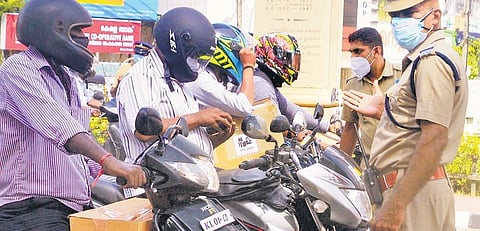 Police officers check documents of two-wheeler riders at Statue Junction in Thiruvananthapuram on Monday. The government has been relying mostly on police officers to enforce restrictions | Vincent P