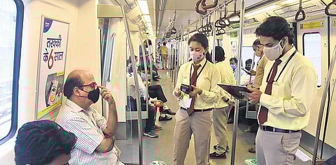 DMRC officials issue challans for violating Covid-19 norms as Delhi Metro resumed services after lockddown on Monday. (Photo | Parveen Negi/EPS)