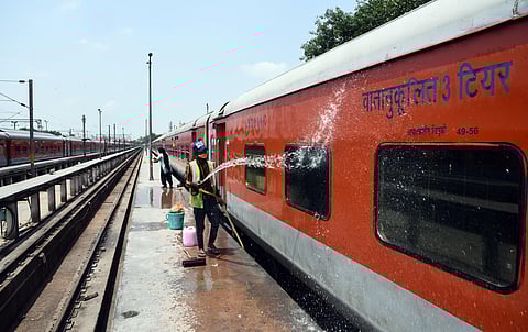 A worker seen engaged in cleaning the railway coaches at the yard in New Delhi Railway station on Sunday. (Photo | Parveen Negi/EPS)