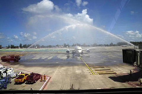 A flight from Abu Dhabi carrying the first group of international tourists to Phuket is ceremoniously showered with water as it arrives at the airport in Phuket. (Photo | AP)