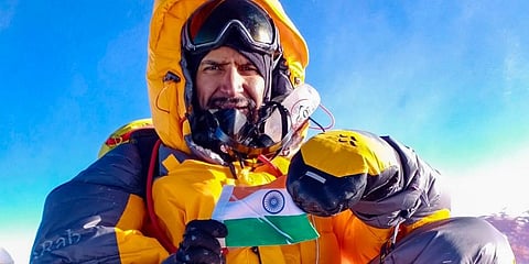 Neeraj Chaudhary shows the Indian flag after scaling Mt Everest within weeks after recovering from COVID-19, near Solukhumbu district. (Photo | PTI)
