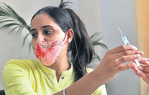 A health worker prepares to administer Covid vaccine to a beneficiary in Delhi. (Photo | Shekhar Yadav, EPS)