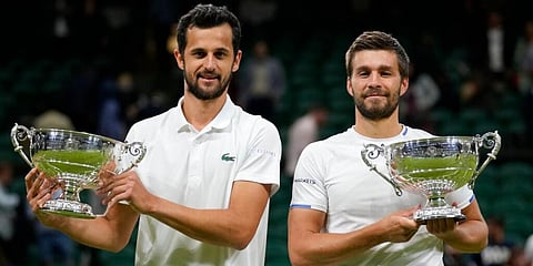 Croatia's Mate Pavic, left, and Nikola Mektic pose with their winners trophies after they won the men's doubles final on day twelve of the Wimbledon Tennis Championships. (Photo | AP)