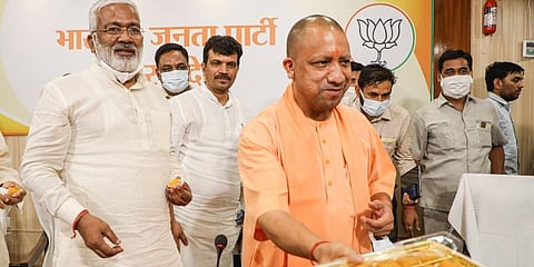 Uttar Pradesh Chief Minister Yogi Adityanath with BJP state President Swatantra Dev Singh celebrates victory in UP Block Panchayat Elections, at party office. (Photo | PTI)