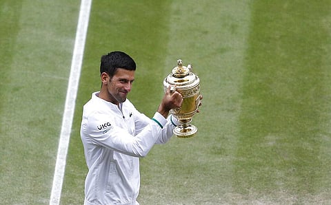 Serbia's Novak Djokovic shows off the winners trophy to the crowd as he walks around Centre Court after defeating Italy's Matteo Berrettini in the men's singles final. (Photo | AP)
