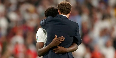 England's manager Gareth Southgate embraces Bukayo Saka after he failed to score in the penalty shootout during the Euro 2020 soccer championship final with Italy on Monday, July 11, 2021 (Photo | AP)