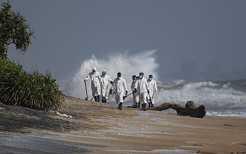 Sri Lankan navy soldiers collect debris that washed ashore from burning ship MV X-Press Pearl anchored off Colombo port at Kapungoda, out skirts of Colombo. (Photo | AP)
