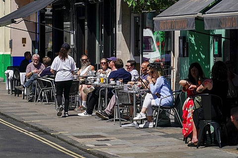 People sit at outdoor tables at a restaurant in Soho, in London (Photo | AP)
