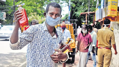 A man with the liquor bottles he bought from a Bevco outlet at Gandhinagar in Kochi