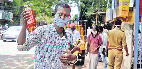 A man with the liquor bottles he bought from a Bevco outlet at Gandhinagar in Kochi | A Sanesh